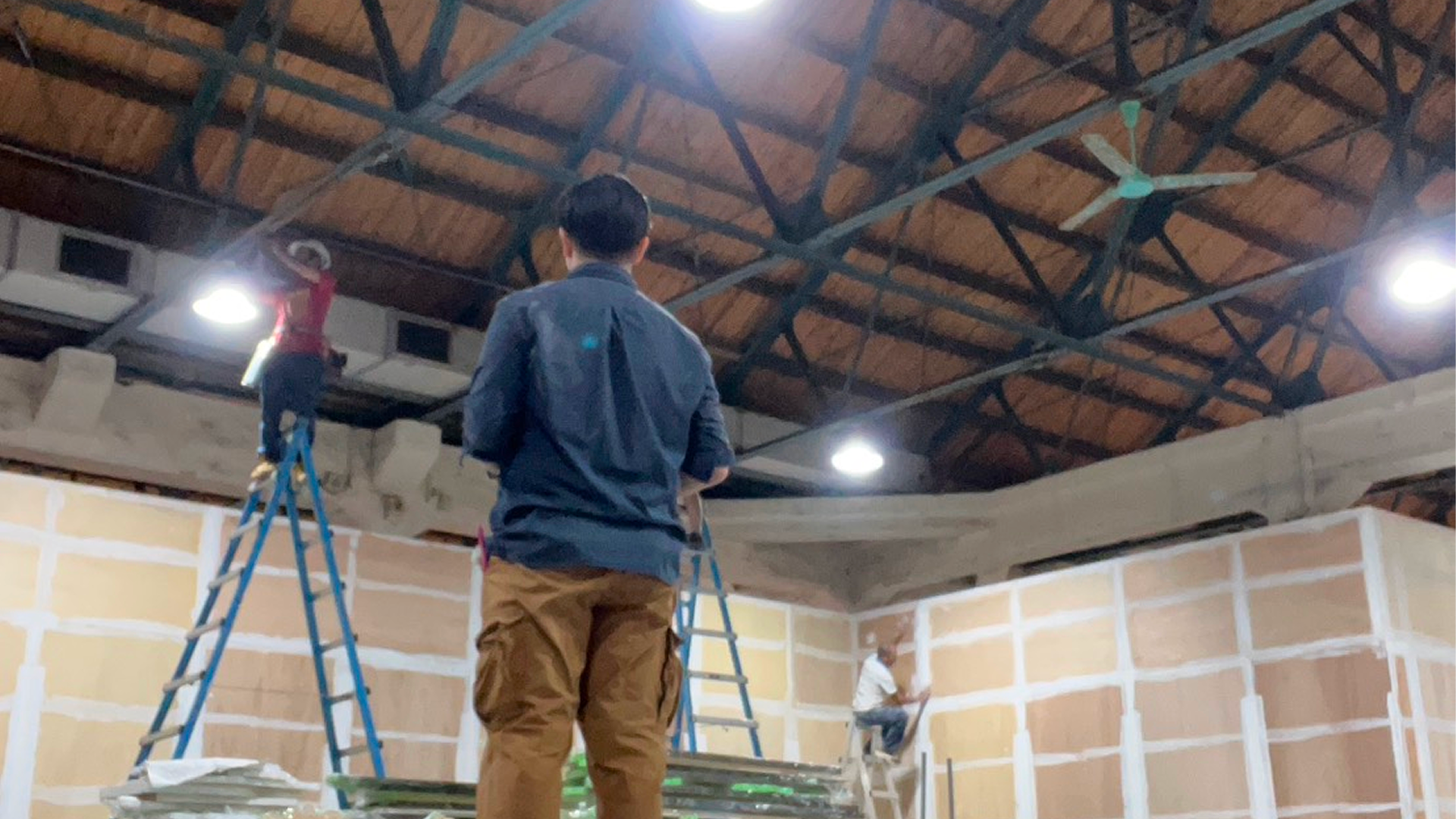 Contractors applying character branding stickers to the panels